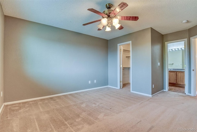 5831 Moon Ridge Dr, Colorado Springs, CO 80922 - unfurnished bedroom with light carpet, baseboards, a walk in closet, a closet, and a textured ceiling