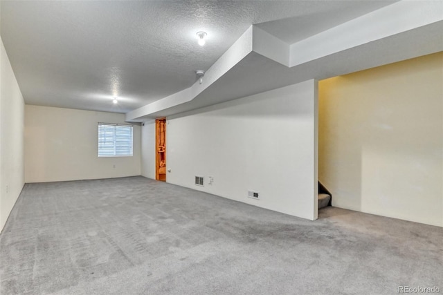 5831 Moon Ridge Dr, Colorado Springs, CO 80922 - basement featuring a textured ceiling, carpet, and stairway