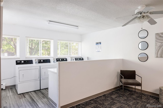 laundry room featuring ceiling fan, washer and clothes dryer, a textured ceiling, and light hardwood / wood-style flooring