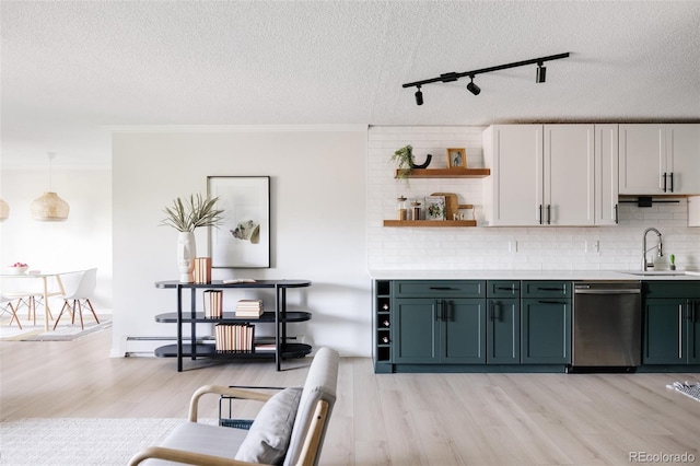 kitchen with dishwasher, sink, hanging light fixtures, track lighting, and white cabinets