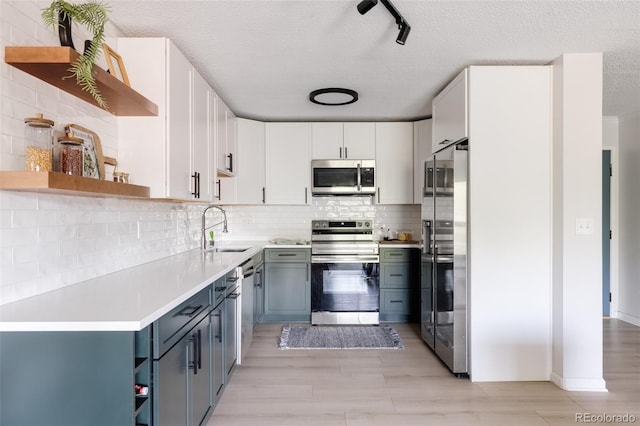 kitchen with gray cabinetry, white cabinets, sink, a textured ceiling, and appliances with stainless steel finishes