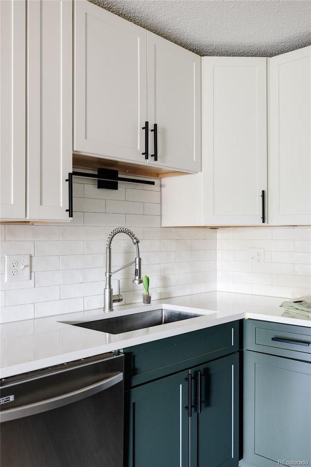 kitchen with backsplash, white cabinets, a textured ceiling, sink, and dishwasher