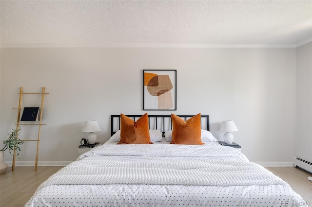 bedroom featuring light hardwood / wood-style floors, ornamental molding, and a textured ceiling