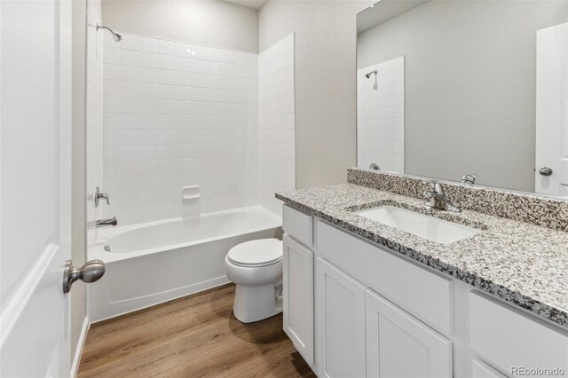 bathroom featuring shower / bathing tub combination, vanity, toilet, and wood finished floors