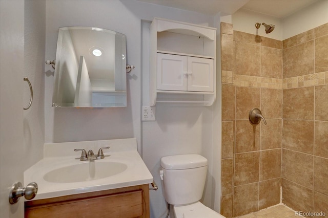 full bath with toilet, tiled shower, and vanity