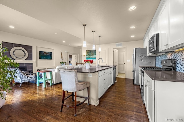 8895 Vanderwood Rd, Colorado Springs, CO 80908 - kitchen with stainless steel appliances, dark countertops, white cabinets, dark wood finished floors, and recessed lighting