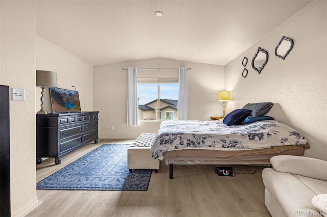 8895 Vanderwood Rd, Colorado Springs, CO 80908 - bedroom with lofted ceiling, wood finished floors, and a textured wall