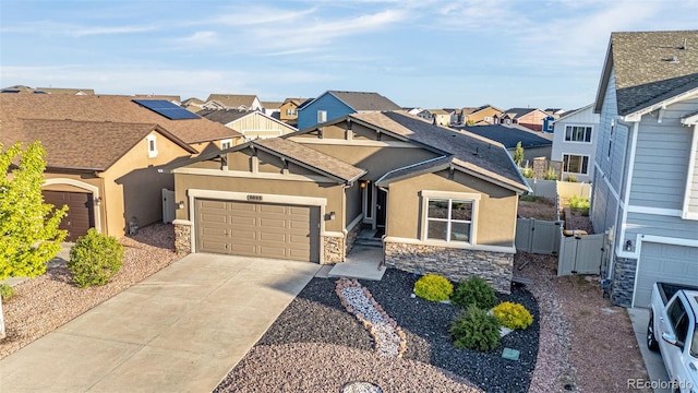 8895 Vanderwood Rd, Colorado Springs, CO 80908 - view of front of home with stone siding, a gate, a residential view, and stucco siding