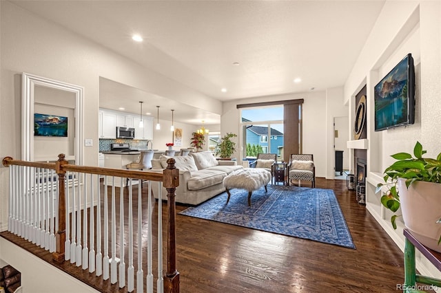 8895 Vanderwood Rd, Colorado Springs, CO 80908 - living area with dark wood-type flooring, recessed lighting, and a lit fireplace