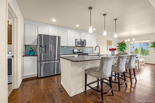 8895 Vanderwood Rd, Colorado Springs, CO 80908 - kitchen featuring stainless steel appliances, dark wood-style flooring, dark countertops, white cabinets, and recessed lighting