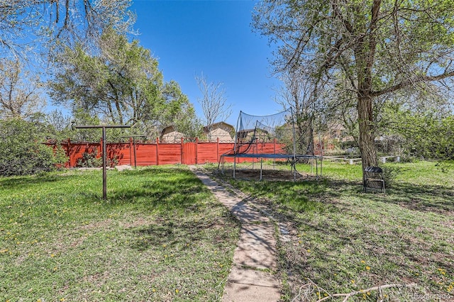 view of yard with fence and a trampoline