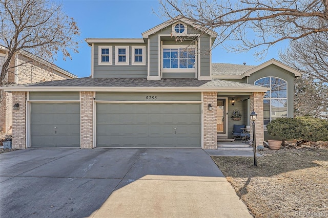 traditional home with concrete driveway, brick siding, and roof with shingles