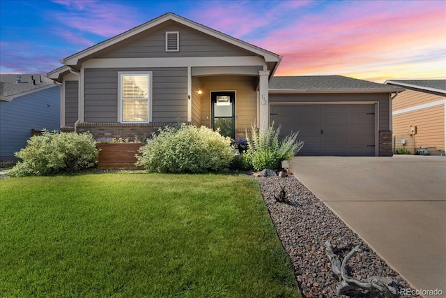 115 Quandary Ave, Berthoud, CO 80513 - view of front of house featuring concrete driveway, brick siding, an attached garage, and a front lawn