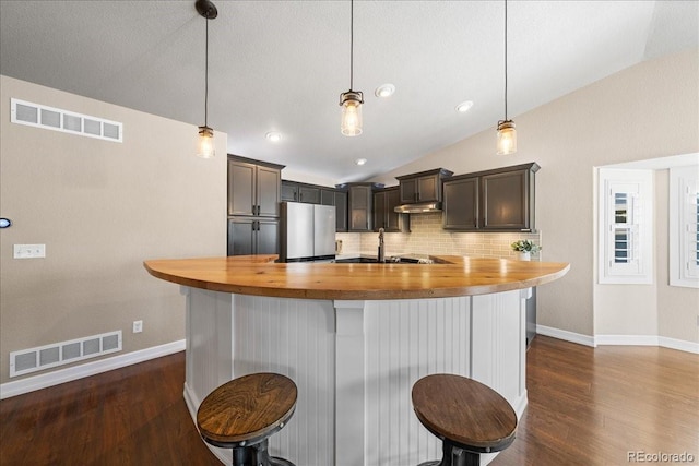 115 Quandary Ave, Berthoud, CO 80513 - kitchen with freestanding refrigerator, butcher block countertops, dark wood finished floors, a breakfast bar area, and vaulted ceiling