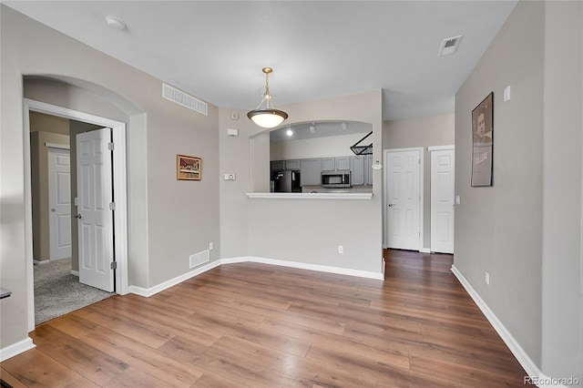 interior space featuring wood finished floors, visible vents, and baseboards