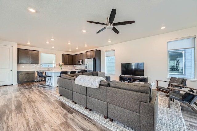 living room with light wood-style floors, recessed lighting, and ceiling fan