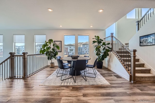 dining room with baseboards, stairway, wood finished floors, and recessed lighting