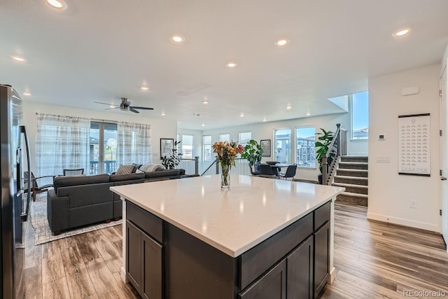 kitchen featuring stainless steel fridge, wood finished floors, and recessed lighting