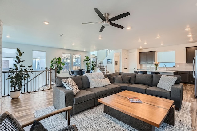 living area featuring recessed lighting, light wood finished floors, and stairs