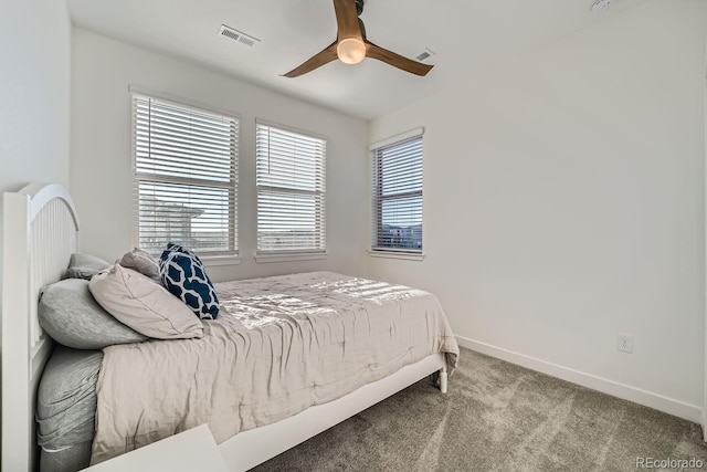 carpeted bedroom featuring a ceiling fan, visible vents, and baseboards