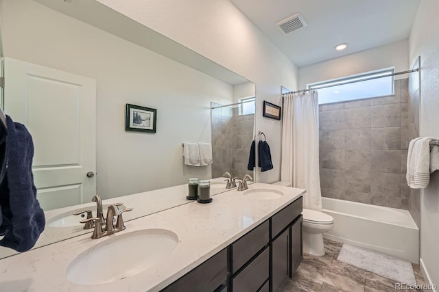 bathroom featuring toilet, a sink, visible vents, and shower / bathtub combination with curtain