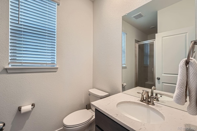 full bath featuring visible vents, a textured wall, toilet, a stall shower, and vanity