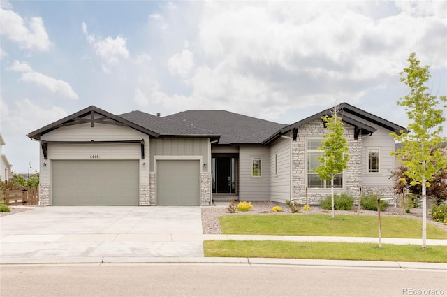 6608 S White Crow Ct, Aurora, CO 80016 - view of front facade featuring stone siding, an attached garage, driveway, and a front lawn