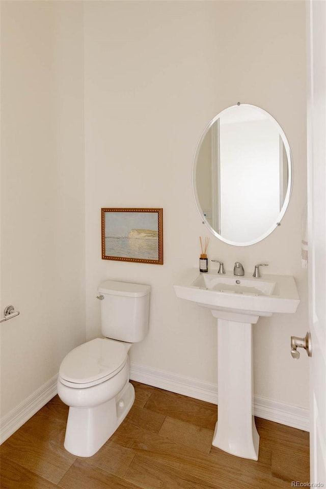 6608 S White Crow Ct, Aurora, CO 80016 - half bathroom with toilet, wood finished floors, and baseboards
