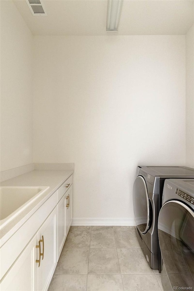 6608 S White Crow Ct, Aurora, CO 80016 - washroom featuring washing machine and dryer, cabinet space, baseboards, and light tile patterned floors
