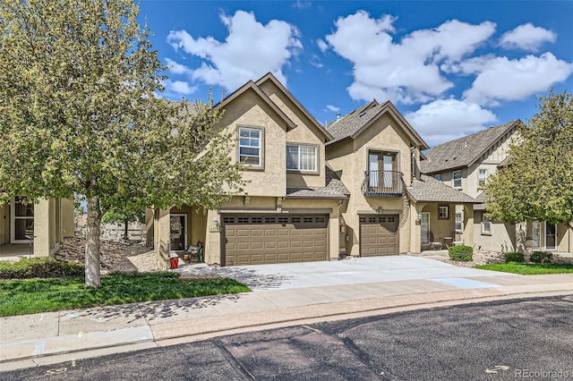 4338 Alder Springs Vw Unit G, Colorado Springs, CO 80922 - view of front of home with a balcony, stucco siding, an attached garage, and concrete driveway