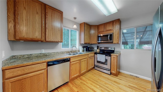 kitchen with tile countertops, plenty of natural light, appliances with stainless steel finishes, and a sink