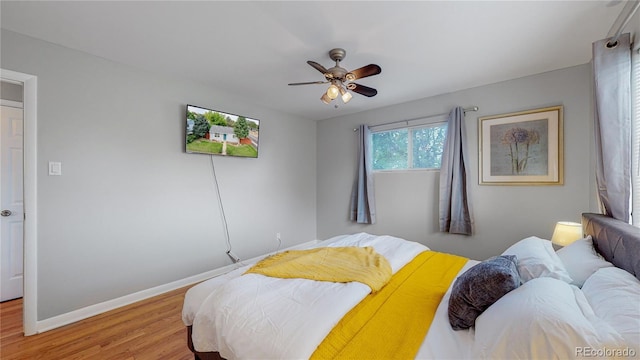 bedroom with light wood-type flooring, ceiling fan, and baseboards