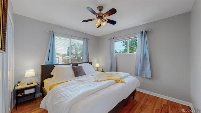 bedroom with wood finished floors, a ceiling fan, and baseboards