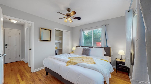 bedroom featuring ceiling fan, a closet, light wood-style flooring, and baseboards