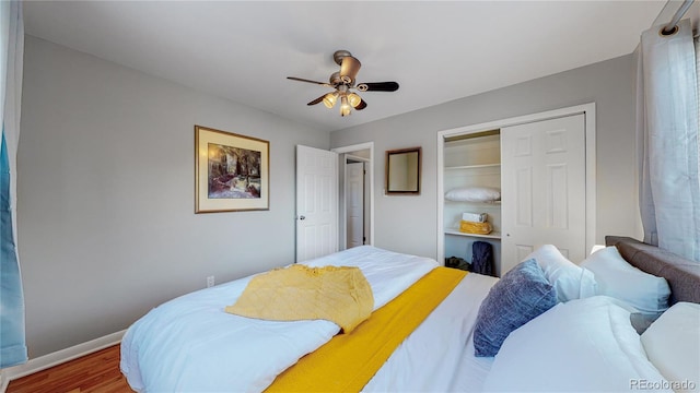 bedroom with a closet, ceiling fan, baseboards, and wood finished floors