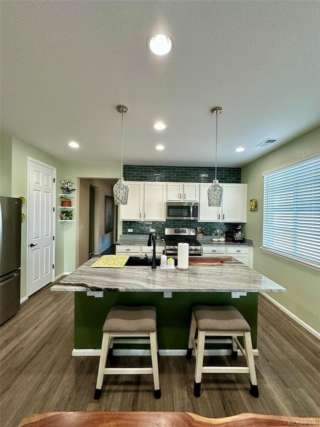 3974 Castle Vista Ln, Castle Rock, CO 80104 - kitchen with stainless steel appliances, backsplash, white cabinetry, dark wood-style floors, and a textured ceiling