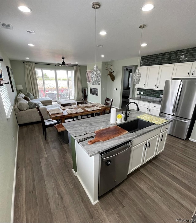 3974 Castle Vista Ln, Castle Rock, CO 80104 - kitchen featuring appliances with stainless steel finishes, dark wood-type flooring, ceiling fan, open floor plan, and white cabinets