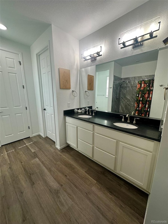 3974 Castle Vista Ln, Castle Rock, CO 80104 - bathroom with a tile shower, double vanity, wood finished floors, a textured ceiling, and a closet