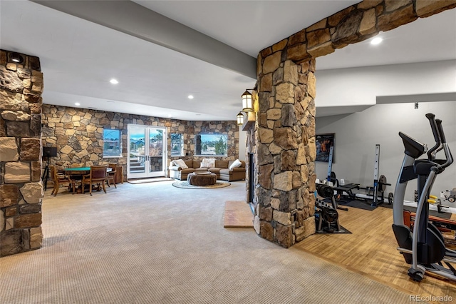 exercise room with carpet floors, a stone fireplace, recessed lighting, and ornate columns