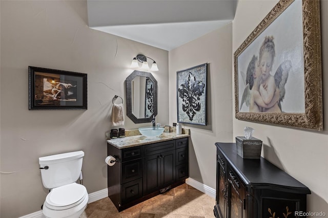 half bath with vanity, toilet, and baseboards