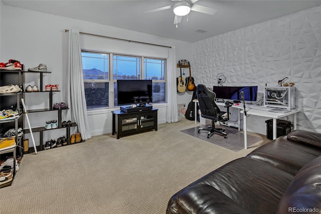 carpeted office space featuring baseboards, visible vents, and a ceiling fan