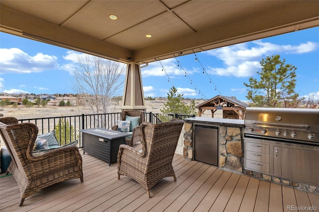 deck featuring an outdoor kitchen, grilling area, and a gazebo