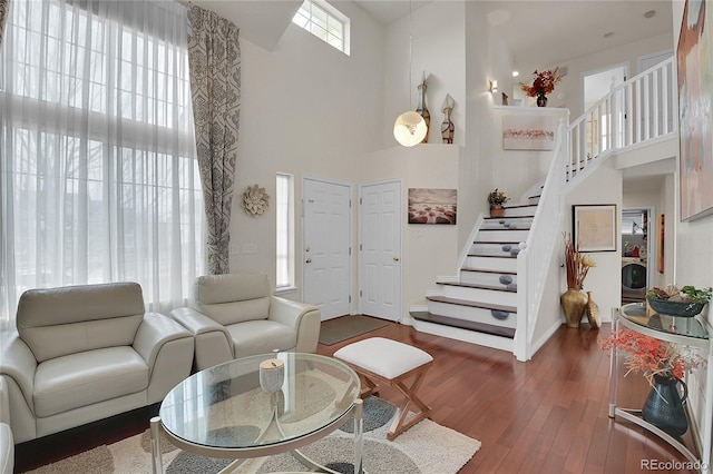 living room featuring dark hardwood / wood-style flooring, a high ceiling, and washer / dryer