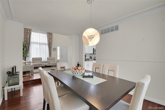 dining space with crown molding and dark hardwood / wood-style floors