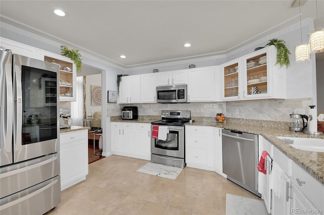 kitchen featuring white cabinets, decorative light fixtures, appliances with stainless steel finishes, and tasteful backsplash