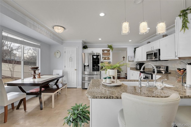 kitchen with white cabinetry, pendant lighting, stainless steel appliances, and light stone counters