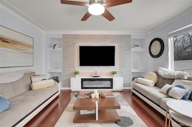 living room with dark hardwood / wood-style flooring, a large fireplace, built in features, and crown molding