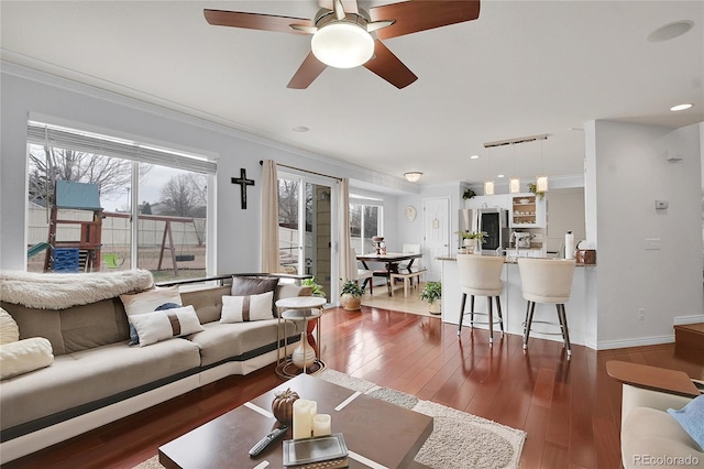 living room with ceiling fan, dark hardwood / wood-style flooring, and ornamental molding