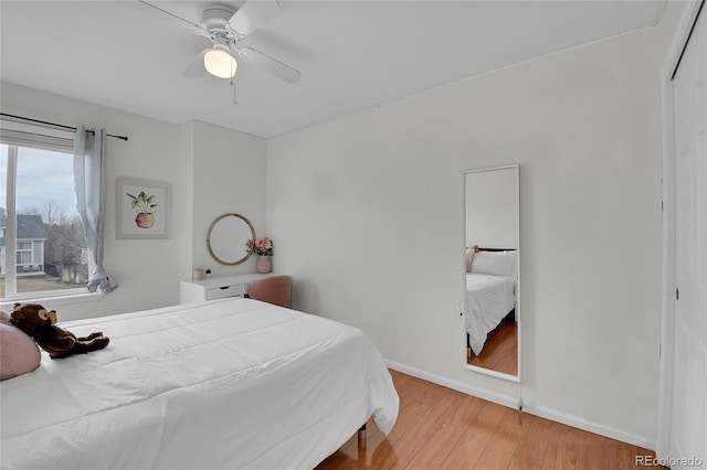 bedroom featuring hardwood / wood-style flooring, ceiling fan, and a closet