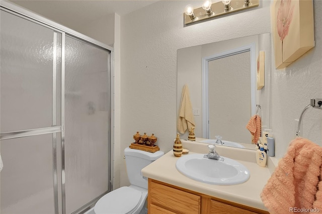 bathroom with toilet, vanity, and walk in shower